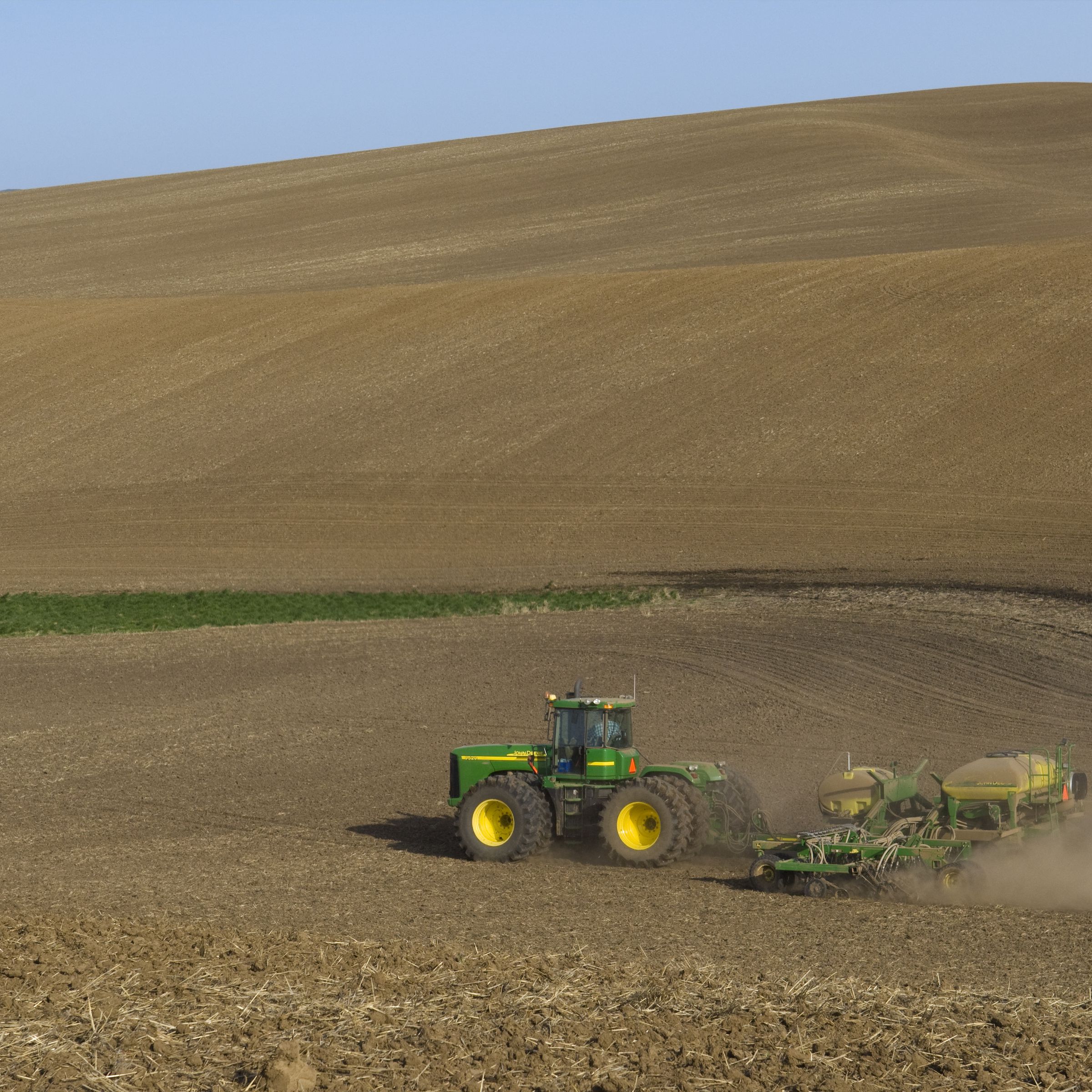A tractor seen driving through a field.