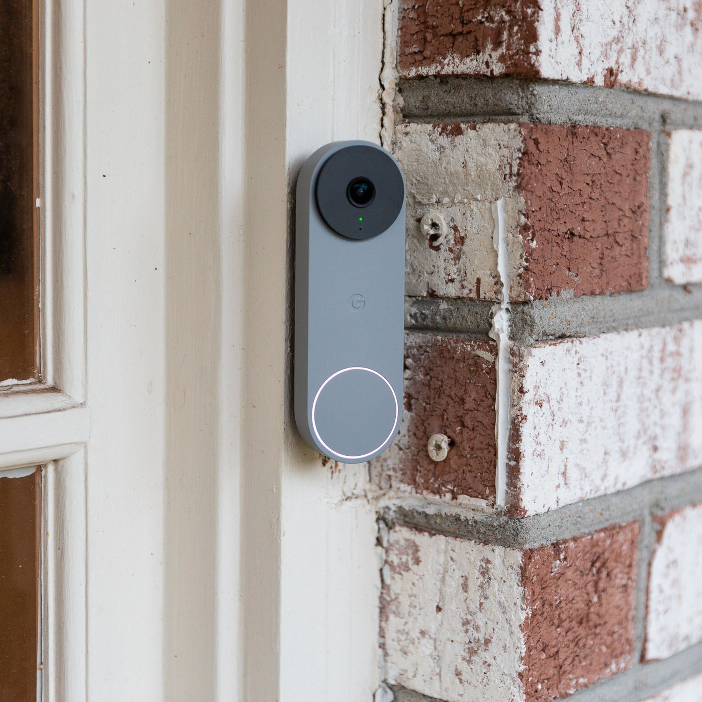 A gray Nest Doorbell on a brick wall
