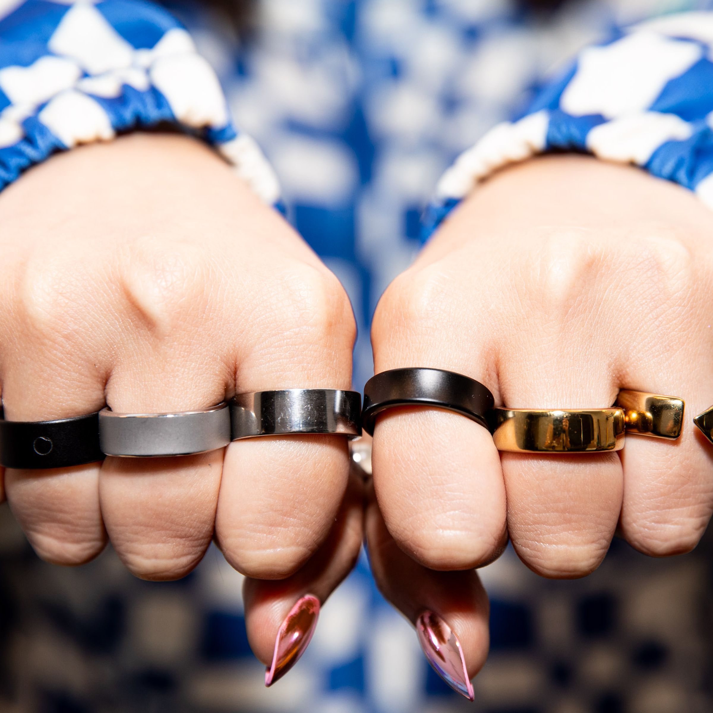 Person wearing six smart rings with their fists forward