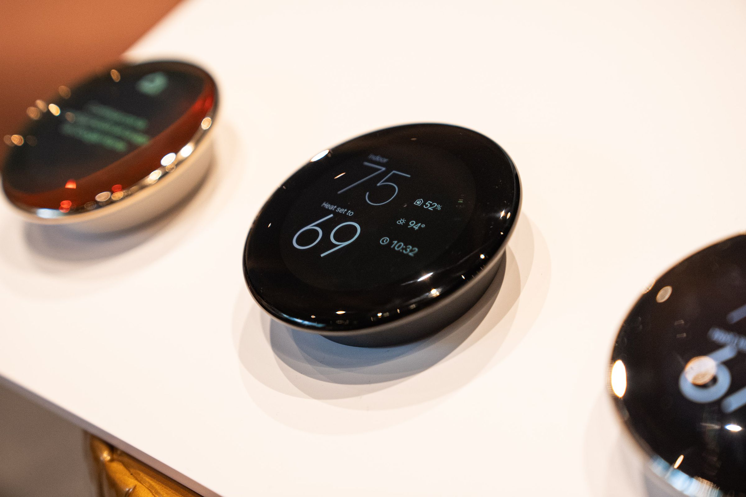 A lineup of fourth-gen Google Nest Learning Thermostats mounted on a display board.