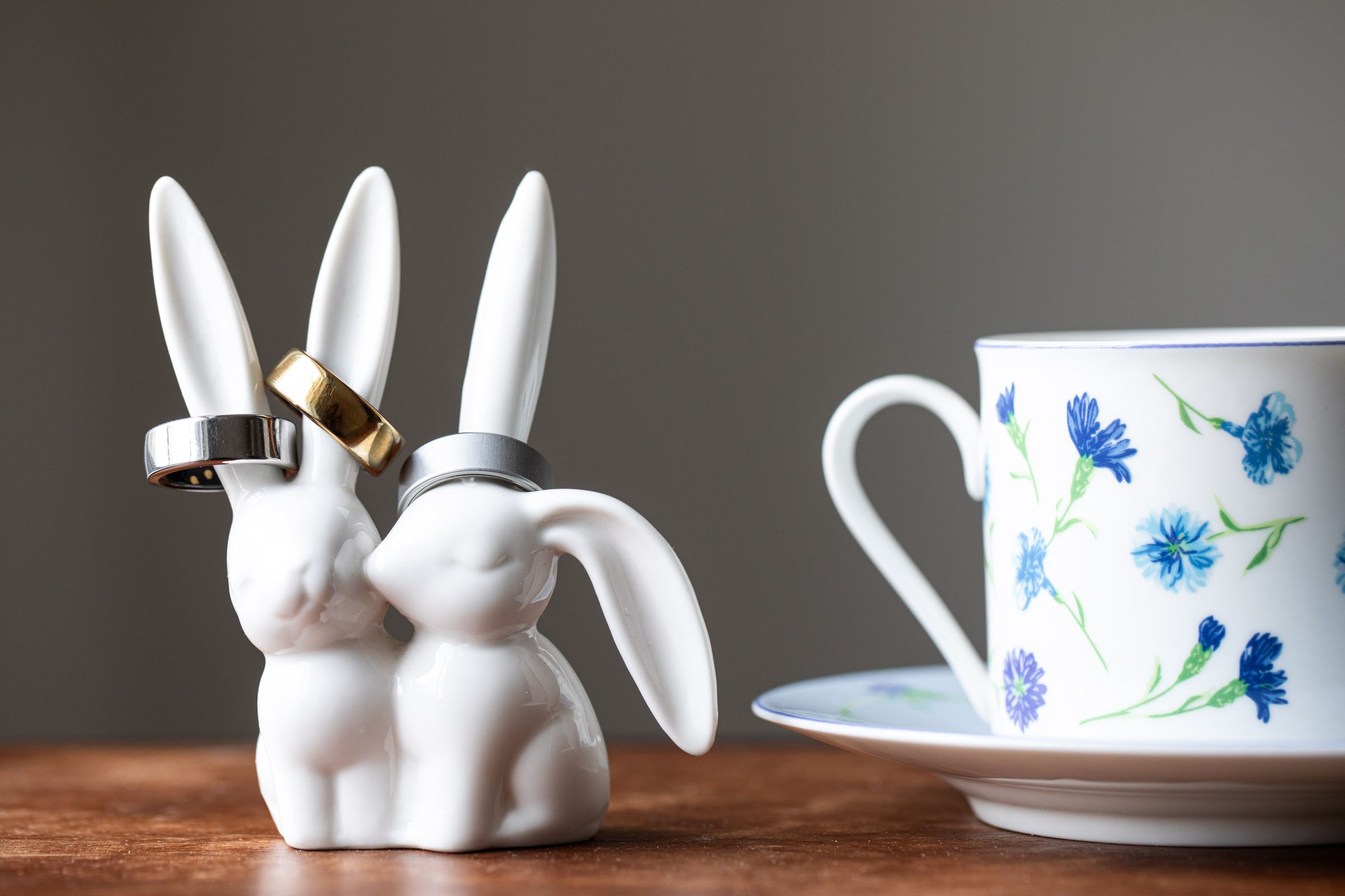Oura Ring 2, 3, and 4 on a ring holder next to a teacup.
