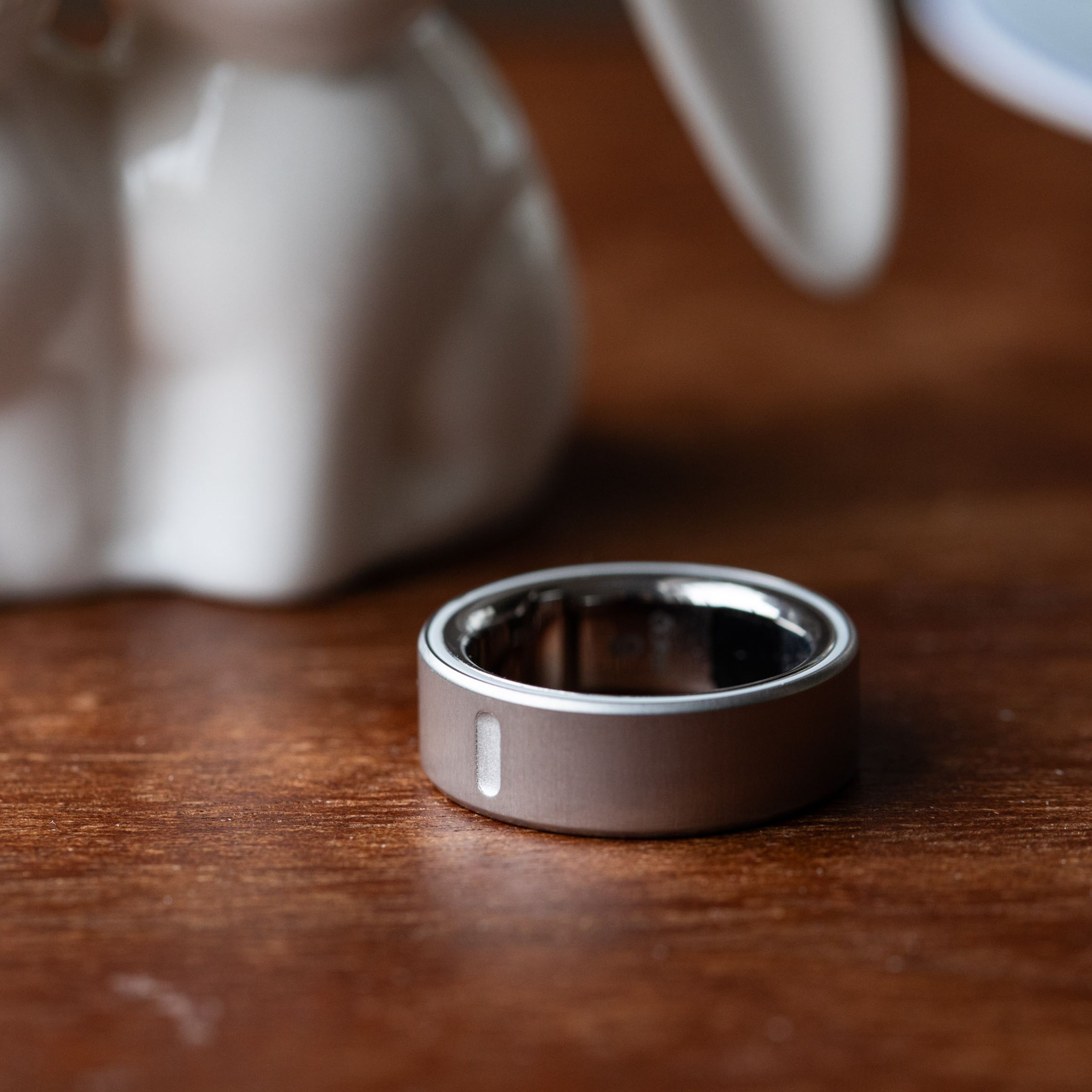 Close up of silver Oura Ring 4 on a wooden surface