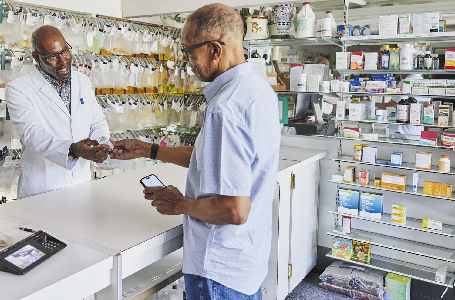 photo of a pharmacist and a customer having a converstion at a counter in a drug store