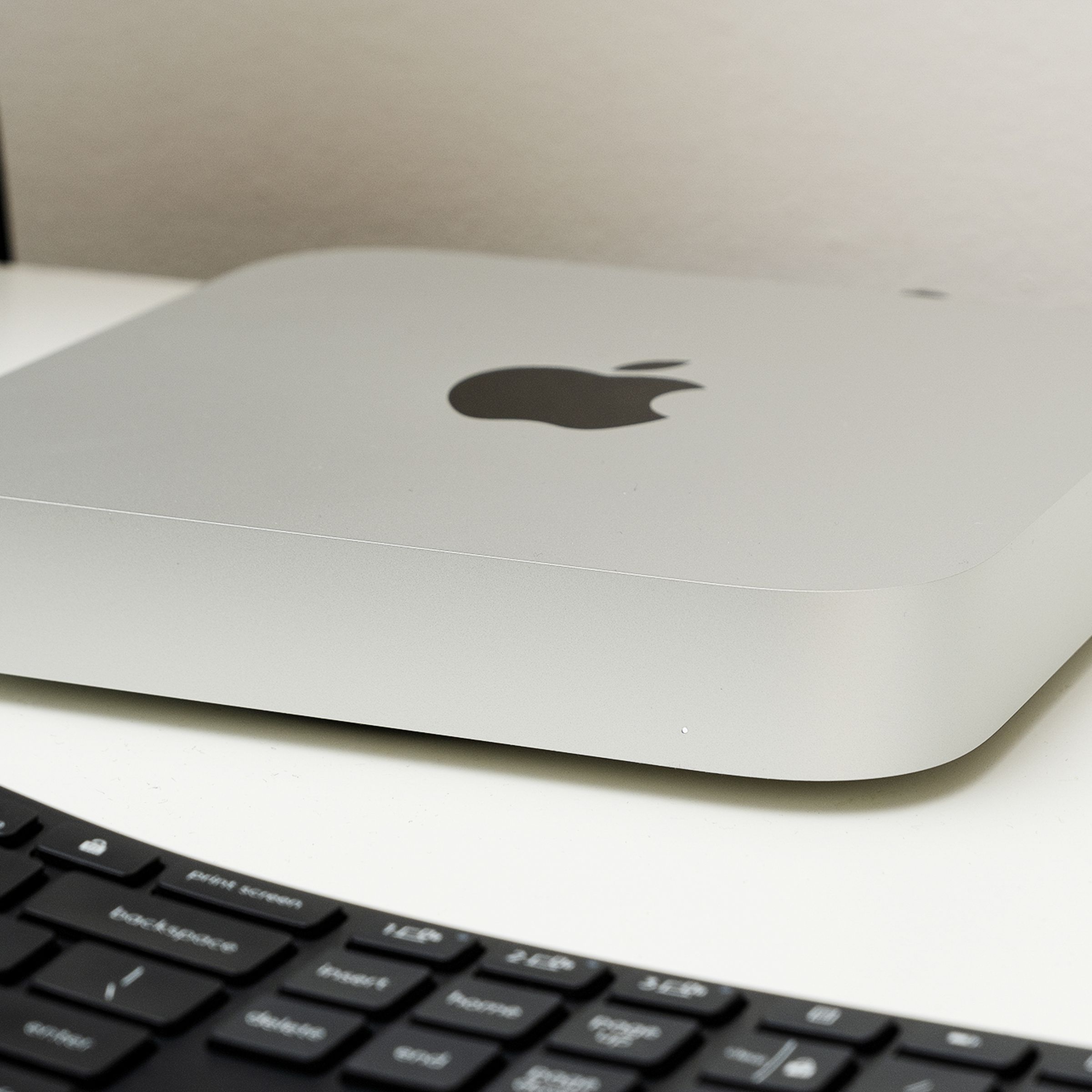 Picture of a Mac Mini sitting on a desk with a keyboard in front of it.