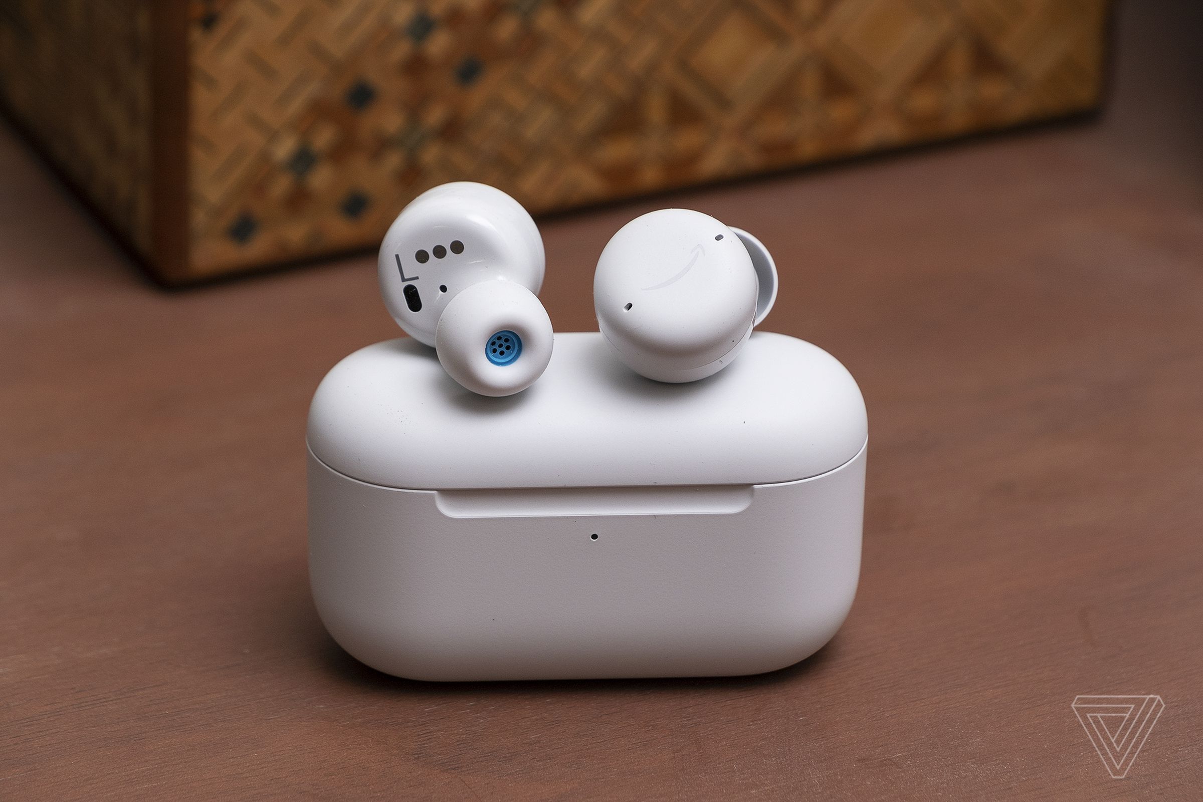A pair of echo buds sitting on top of charging case