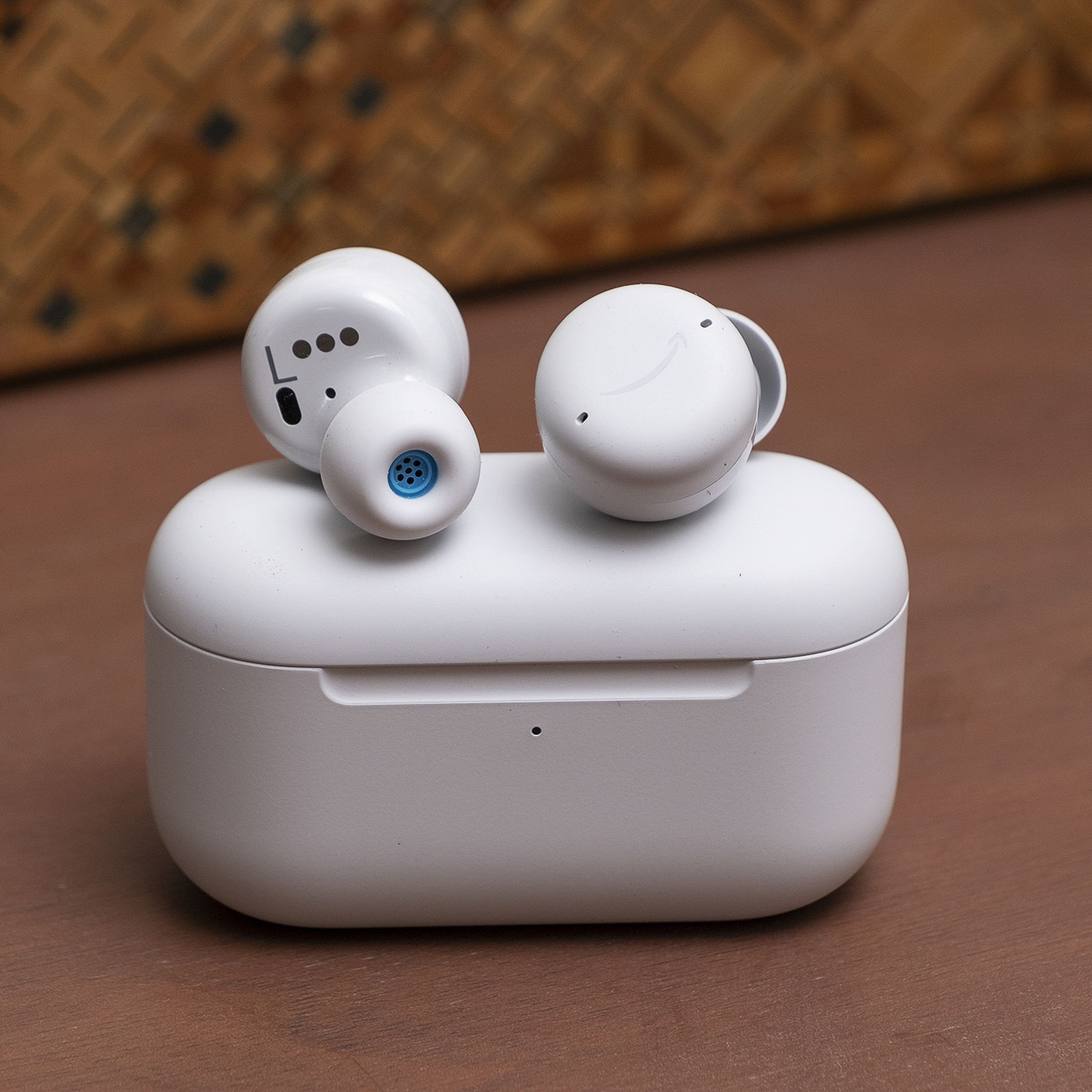 A pair of echo buds sitting on top of charging case