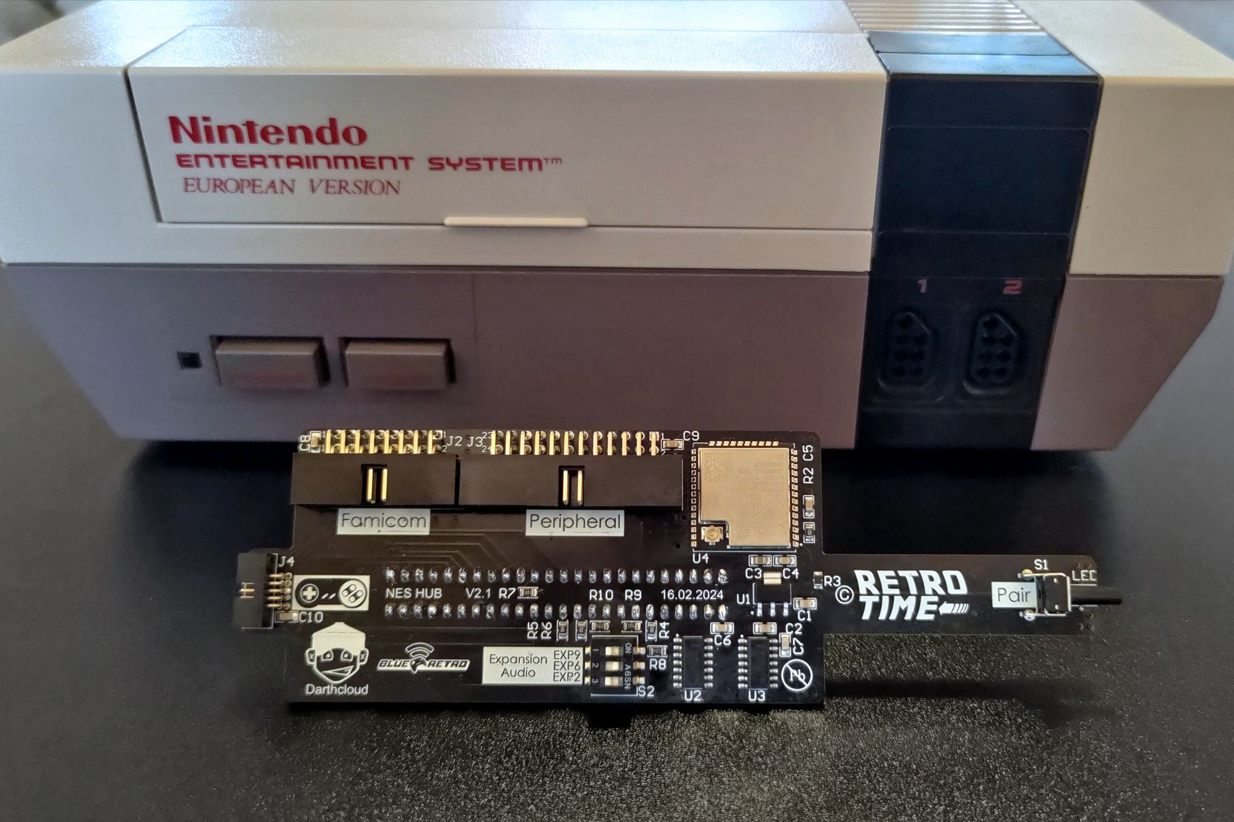 An early version of the NES Hub in front of a European version of the NES console.
