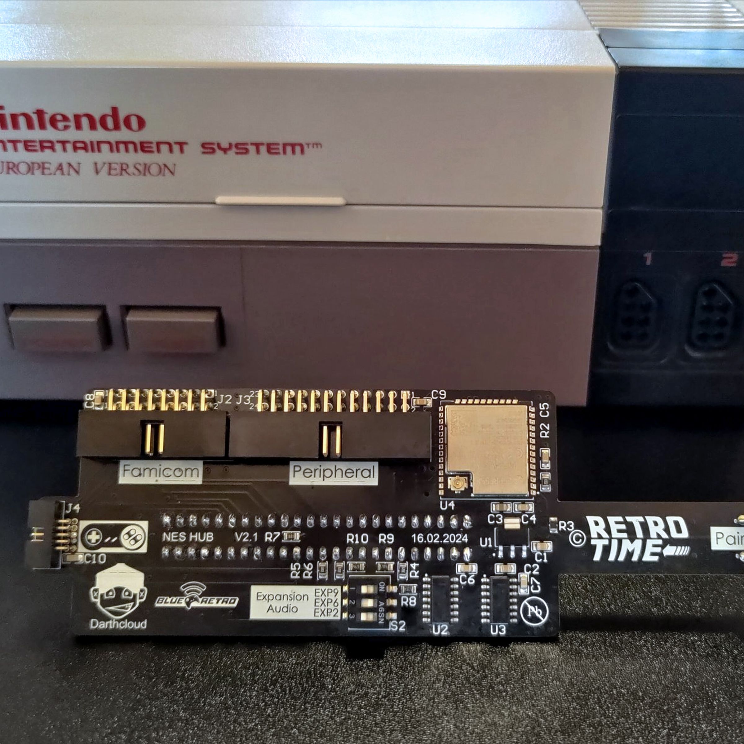 An early version of the NES Hub in front of a European version of the NES console.