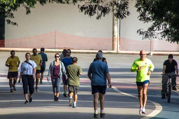 Runners, joggers, walkers, and a cyclist all moving along a pathway.