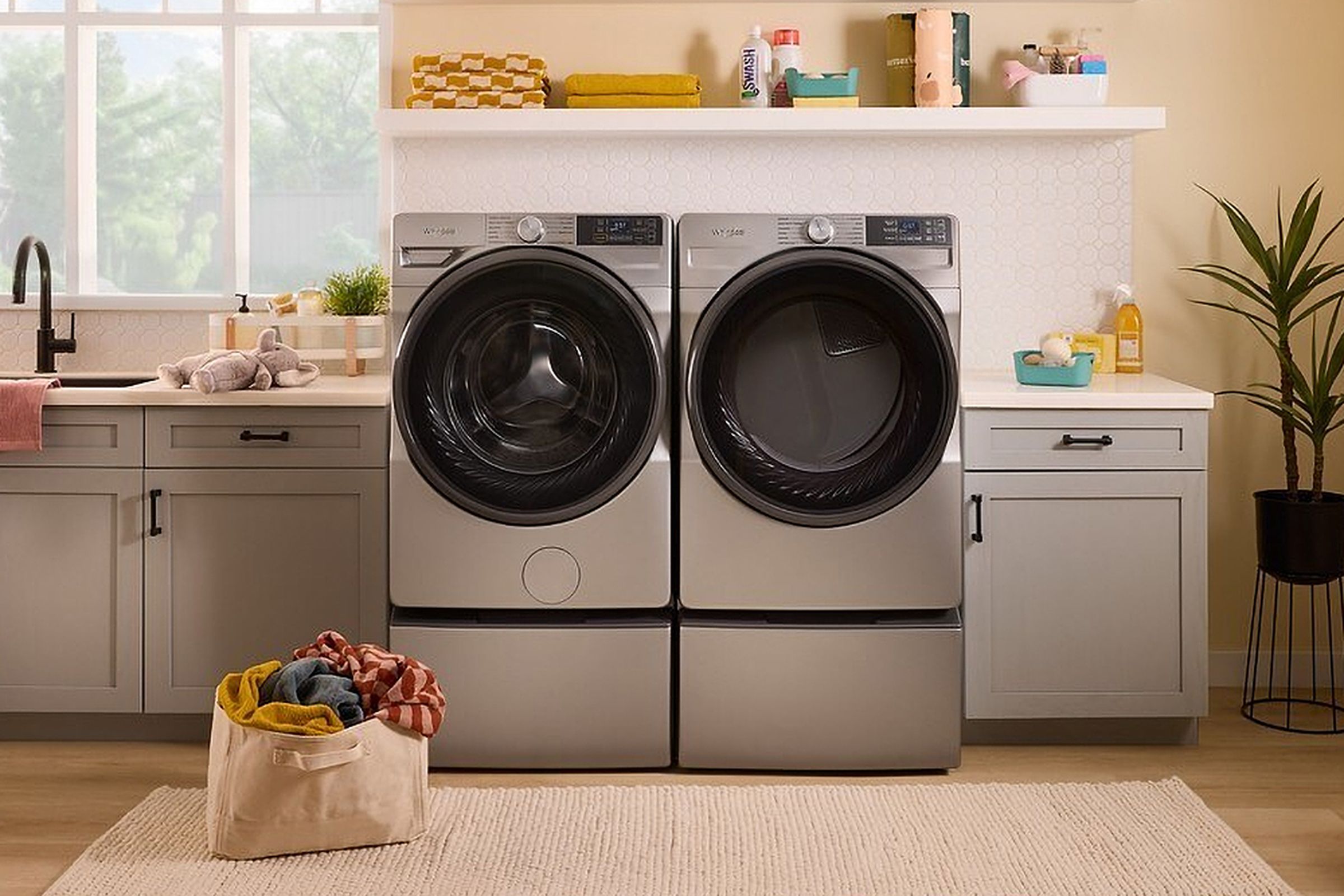 A Whirlpool washer and dryer inside a well-appointed laundry room.