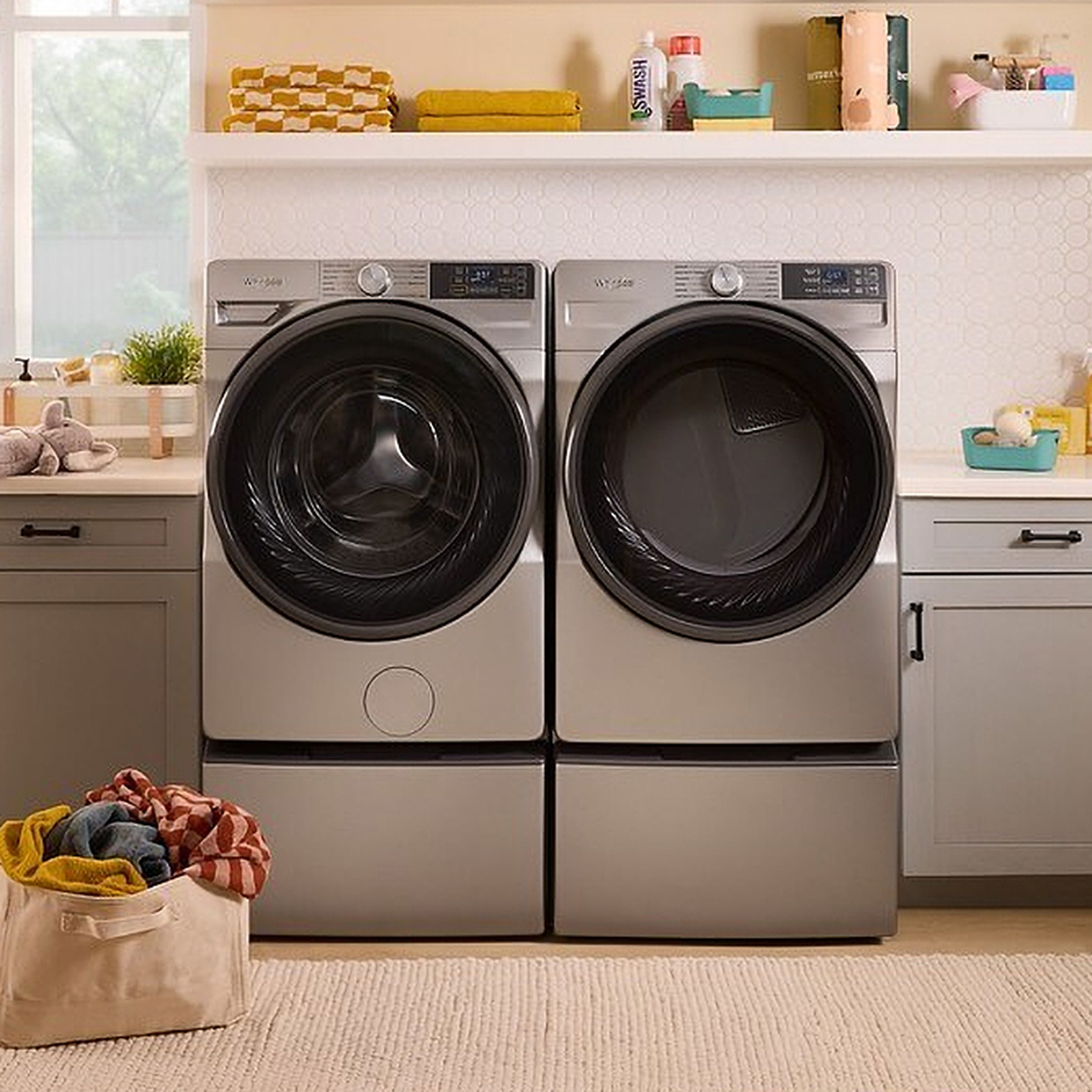 A Whirlpool washer and dryer inside a well-appointed laundry room.